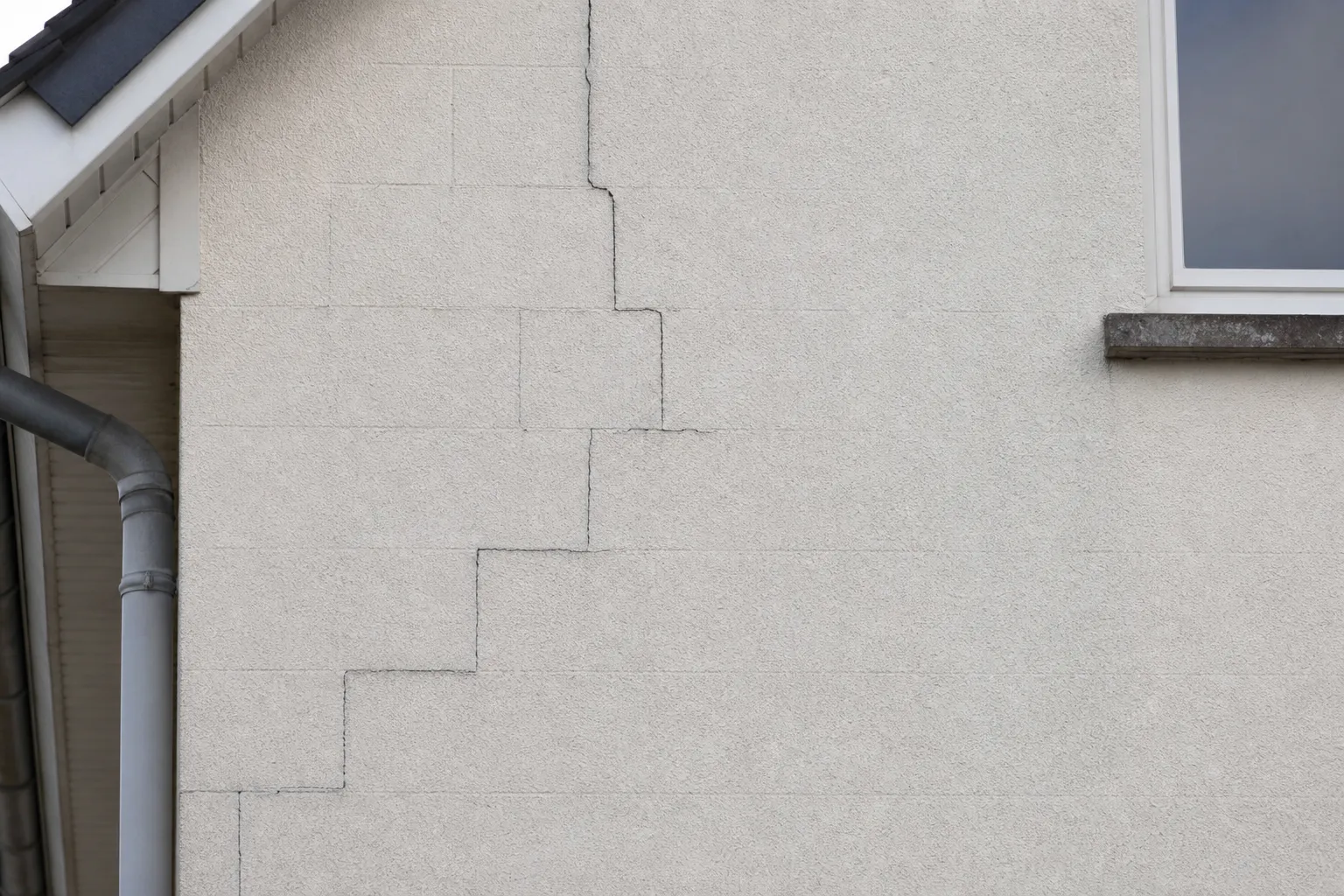 Expert en bâtiment Check my House diagnostiquant une fissure sur la façade d'une maison dans le Val-d'Oise (95)